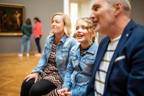 Eine Familie betrachtet Kunst im Museum.